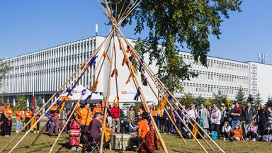 Groupe de personnes rassemblé devant un tipi