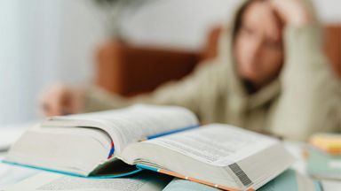 Un étudiant face à des livres