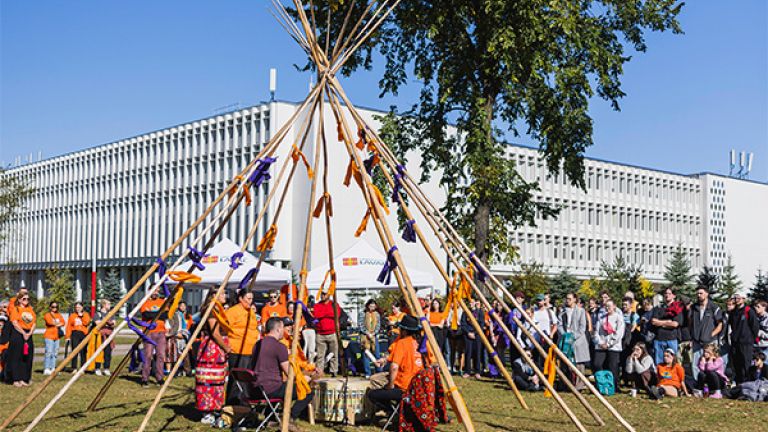 Groupe de personnes rassemblé devant un tipi
