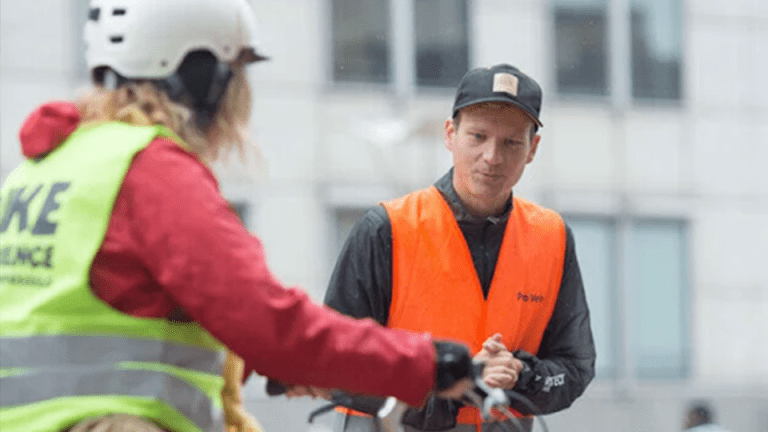 Formateur qui accompagne une cycliste dans le cadre de la formation